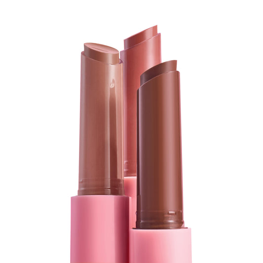 Lush Pout trio - twist-up ColourPop So Juicy Plumping Gloss Balm with Peptides - stands uncapped to show glossy nude, rose, and cocoa bullets in pink tubes, highlighting the bundle's hydrating, plumping finish on a white backdrop.