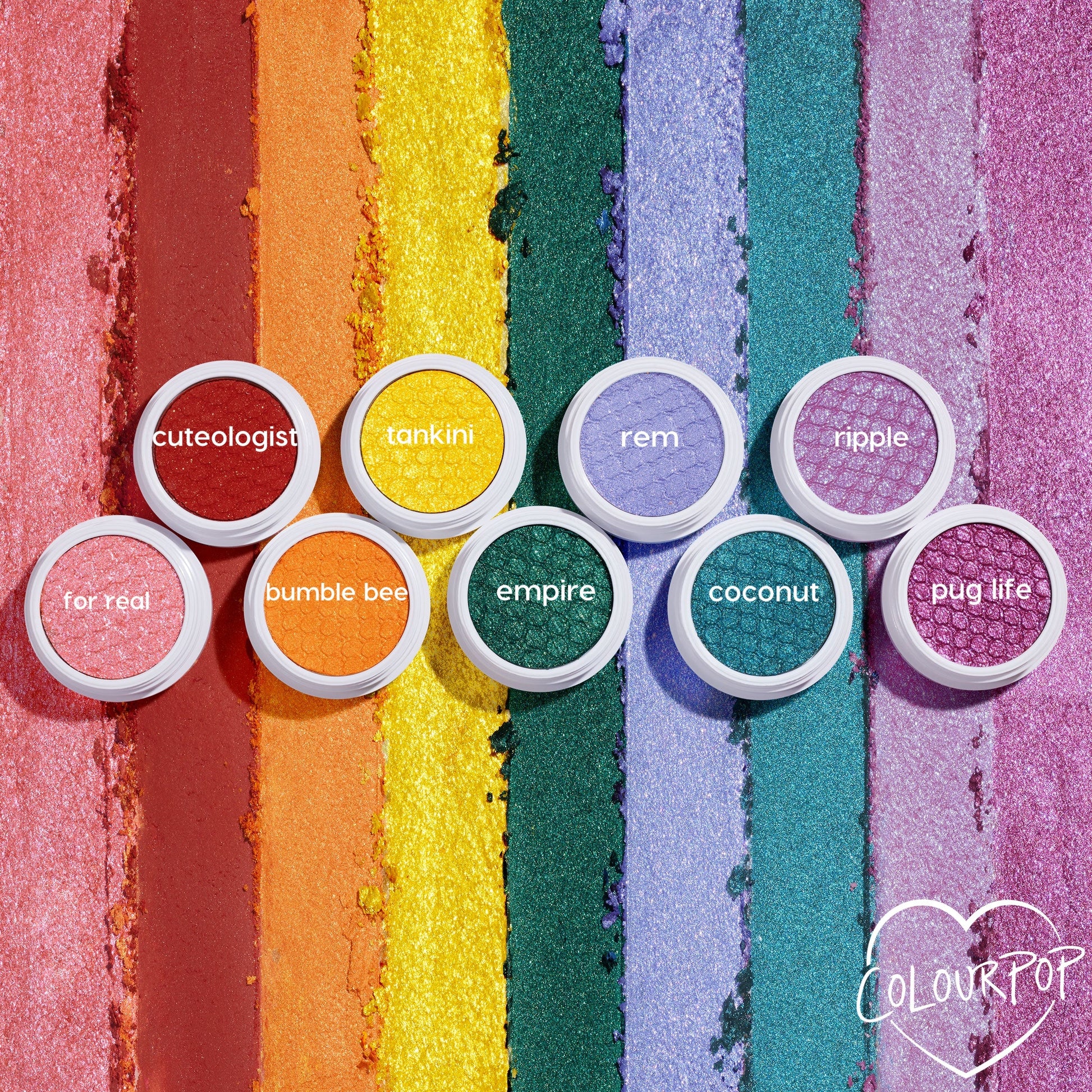 Empire Super Shock Shadow by ColourPop glows as a metallic emerald single in a white pot, centered on a flat lay of rainbow shimmer swatches and companion shades, showcasing rich green payoff and bouncy cream-to-powder texture.