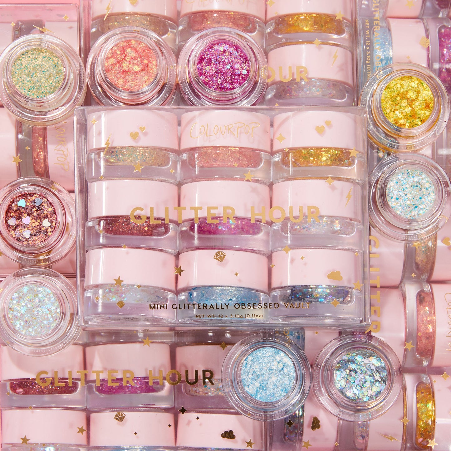 Glitter Hour jars arranged in a top-down grid, displaying ColourPop Glitter Gel minis in pink pots with gold stars, featuring chunky and fine mixes in gold, fuchsia, blue, and iridescent flakes, some with heart confetti.