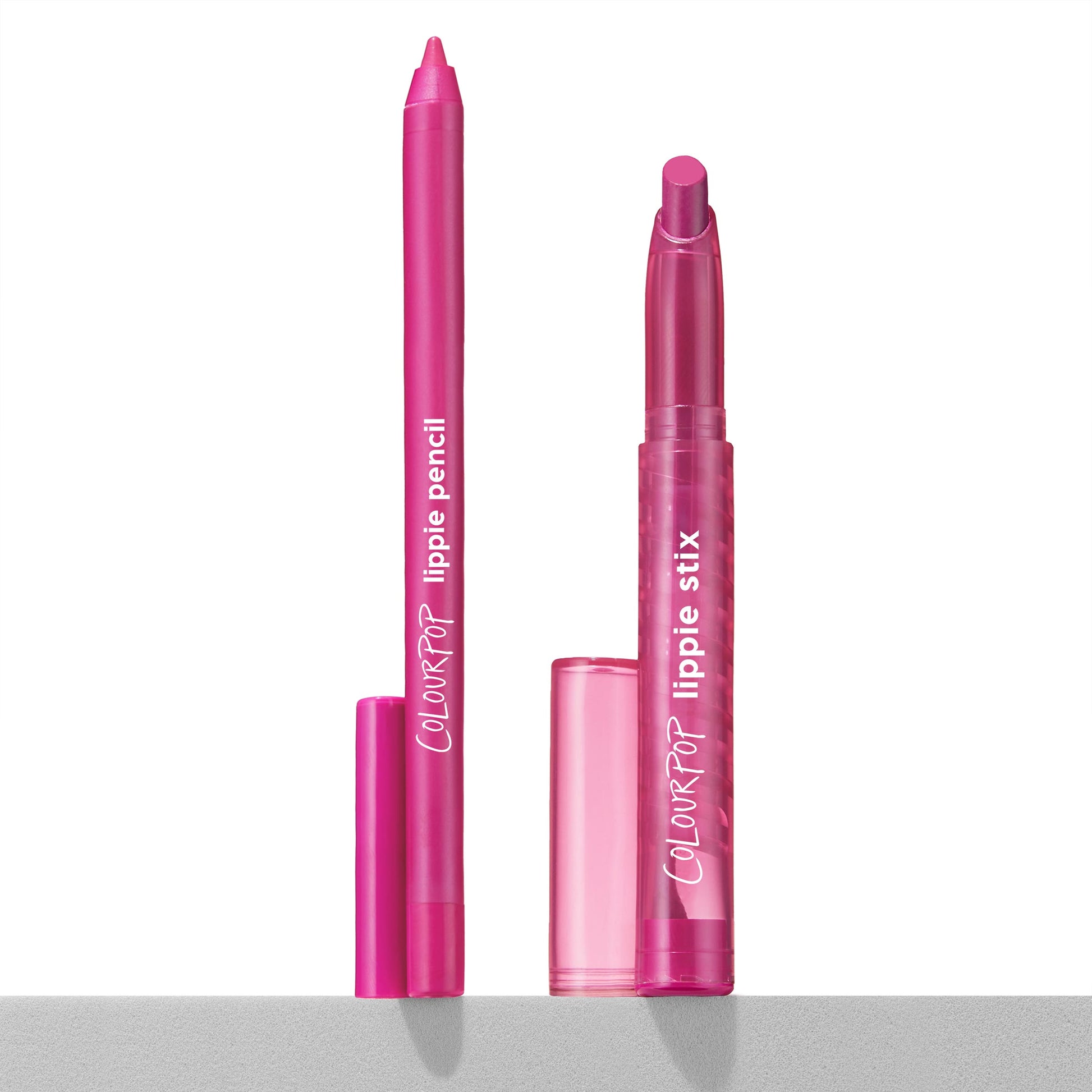 Heart Lips ColourPop Lippie Stix + Pencil Set showing the creamy fuchsia lipstick and matching liner uncapped, upright on a white surface with translucent pink caps nearby and ColourPop branding visible.
