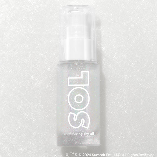 Like Diamonds pump bottle displaying iridescent micro-shimmer through frosted glass with bold white SOL logo, ColourPop SOL Shimmering Dry Oil, standing upright on a silver glitter backdrop that enhances the sparkle for a luminous body glow.