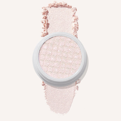 Colourpop Mountain Lion Super Shock Shadow single pan with a shimmery pale pink shade, showing its textured metallic finish and a soft swatch of the powder on a light background for detailed eyeshadow color payoff view.