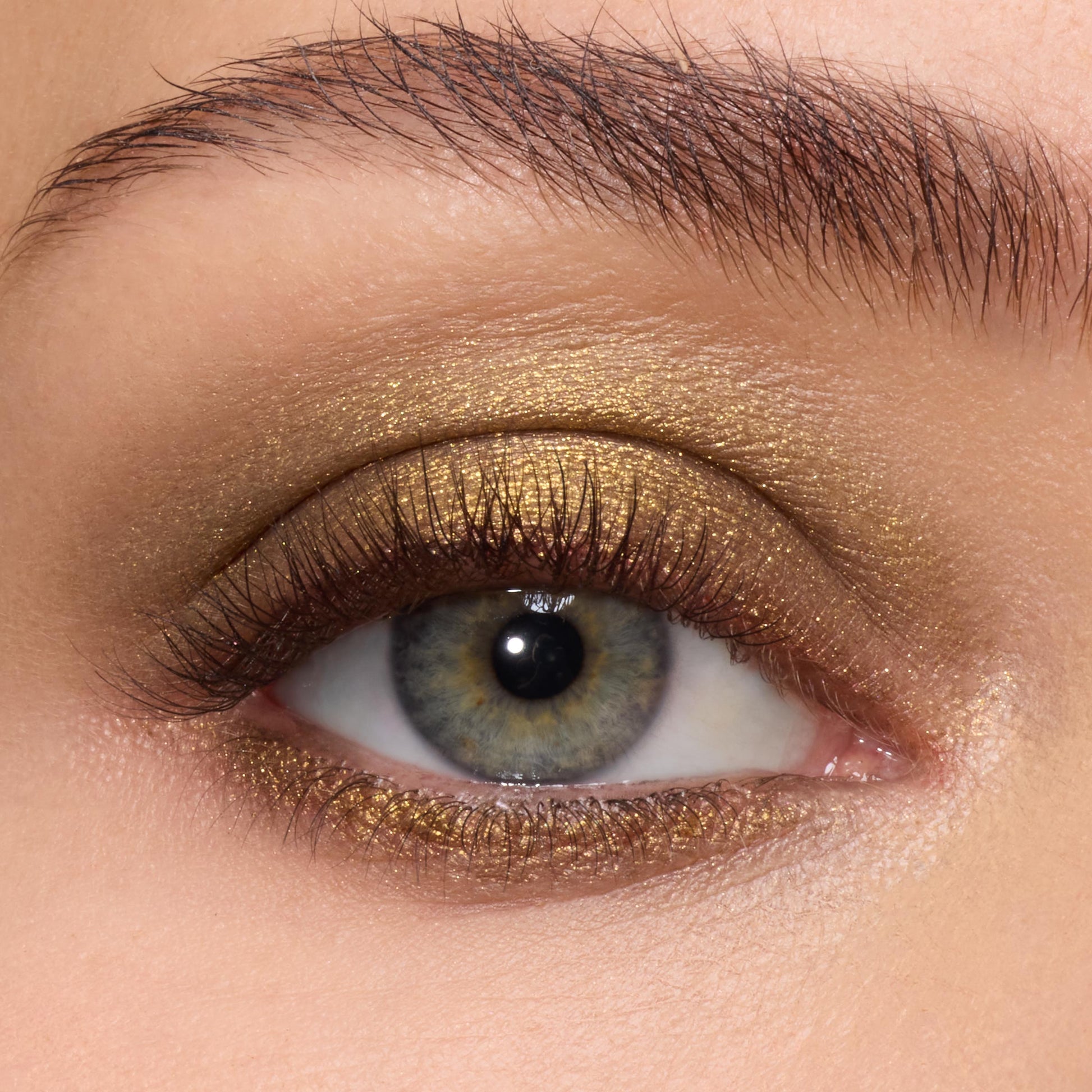 Metallic olive-gold shadow sweeping across the lid and lower lash line, showcasing the creamy payoff of ColourPop Super Shock Shadow We Won’t Bite on a close-up eye with soft lashes and a groomed brow.