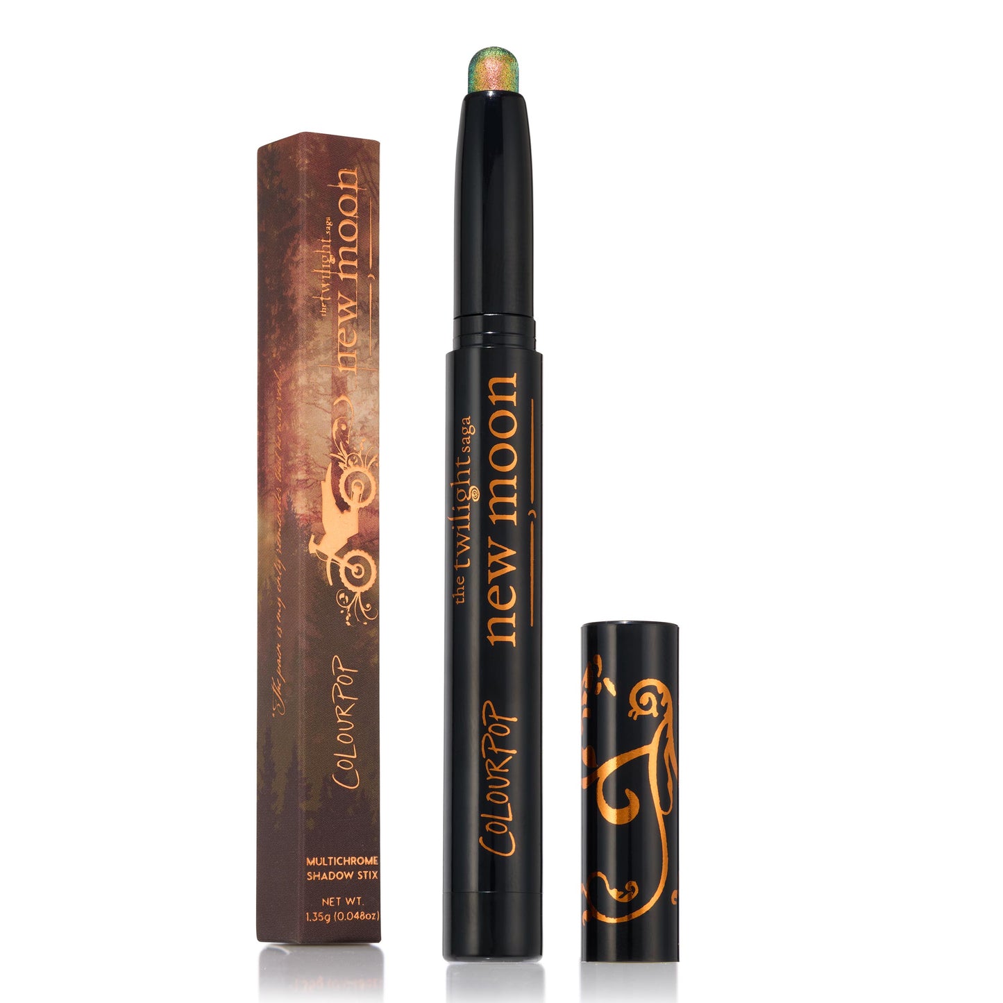 ColourPop Shadow Stix in It’s Always Been Him stands uncapped to reveal a multichrome green‑gold‑pink shimmer tip, with the black “the twilight saga new moon” tube beside its matching illustrated box and cap on a clean white background.