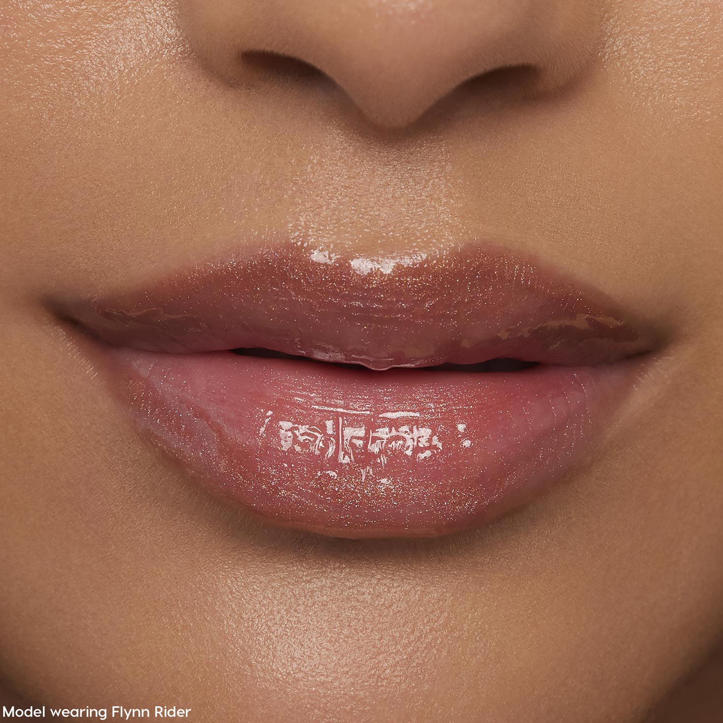 Glossy nude-pink lips wearing ColourPop Ultra Glossy Lip in Flynn Rider, reflecting a high-shine finish with subtle shimmer in a tight face close-up, showcasing smooth, hydrated texture for everyday wear.